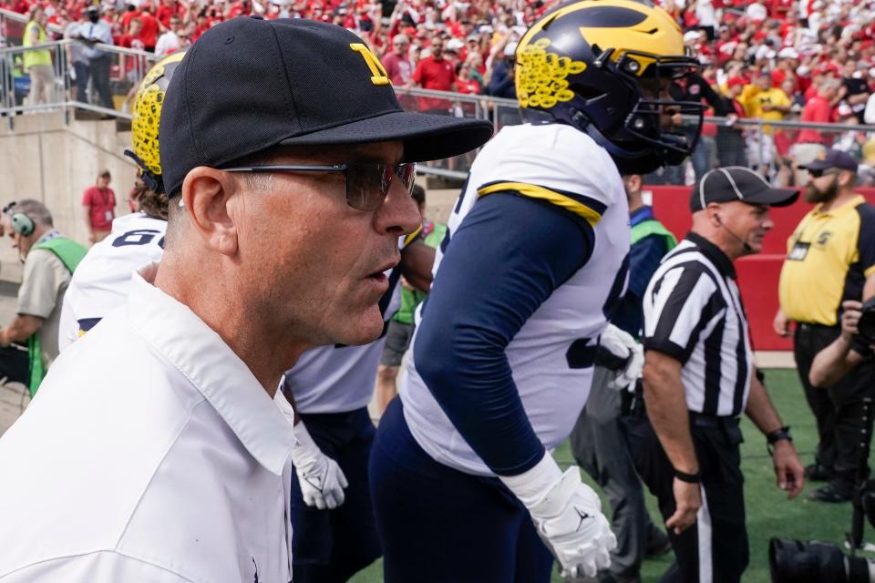 Michigan head coach Jim Harbaugh leads his team on the field before an NCAA college football game against Wisconsin Saturday, Oct. 2, 2021, in Madison, Wis.