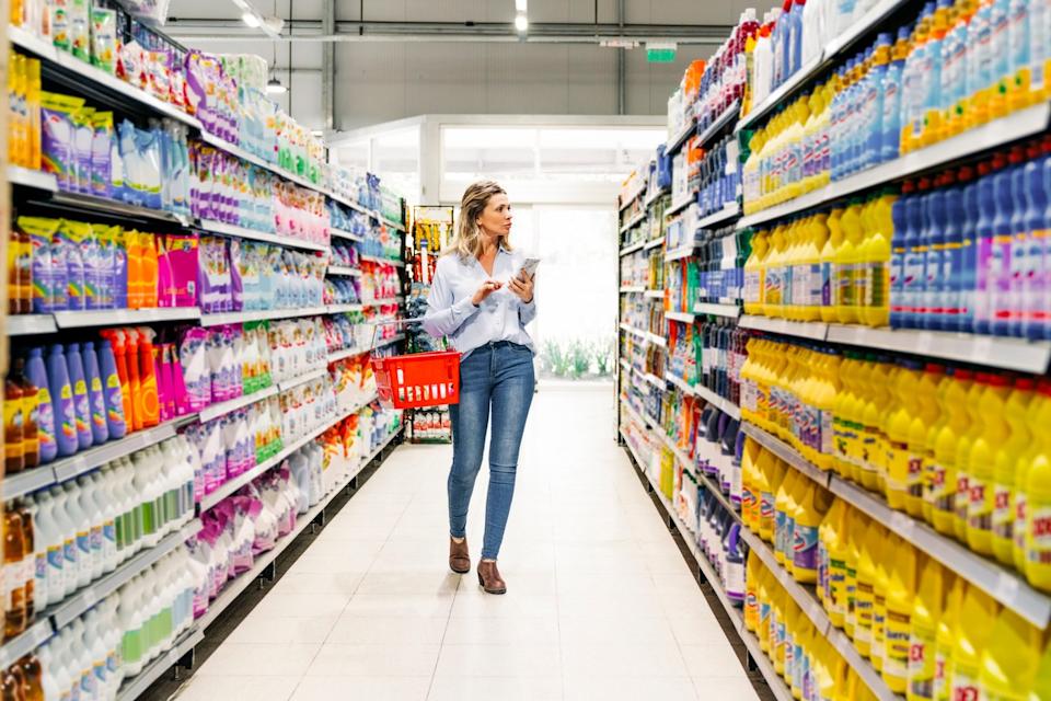 Person walking down store aisle, looking at products on display.