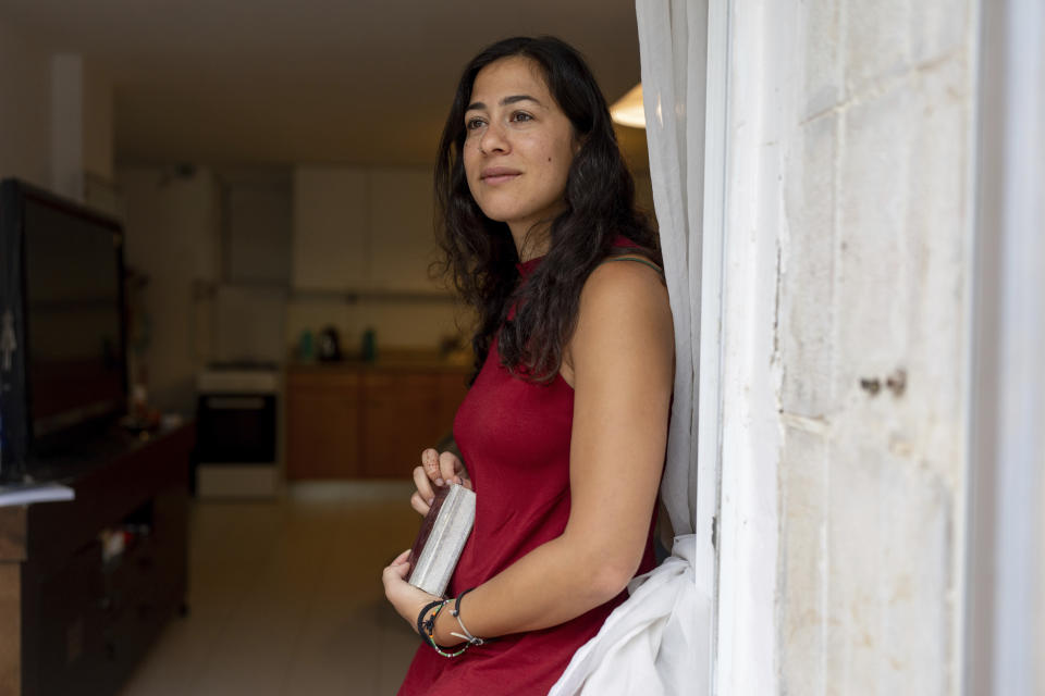 Tamar Shabtai holds a Jewish prayer book at her home in Mevaseret Zion near Jerusalem, Wednesday, Aug. 30, 2023. Shabtai, 29, who grew up in a religious neighborhood in Jerusalem, is among the thousands of young people who leave Israel's ultra-Orthodox community each year. (AP Photo/Ohad Zwigenberg)