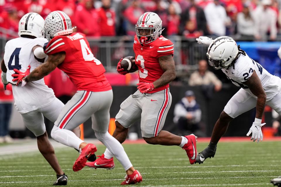 Oct 21, 2023; Columbus, Ohio, USA; Ohio State Buckeyes running back Miyan Williams (3) runs past Penn State Nittany Lions linebacker Curtis Jacobs (23) during the second half of the NCAA football game at Ohio Stadium. Ohio State won 20-12.