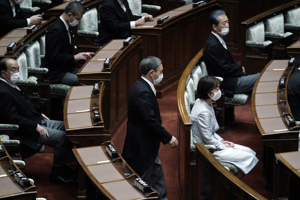 Japan's new Prime Minister Yoshihide Suga walks in to attend an extraordinary session at the upper house of parliament Thursday, Sept. 17, 2020, in Tokyo. Suga started his first full day in office Thursday, with a resolve to push for reforms for the people, and he said he is already taking a crack at it. (AP Photo/Eugene Hoshiko)