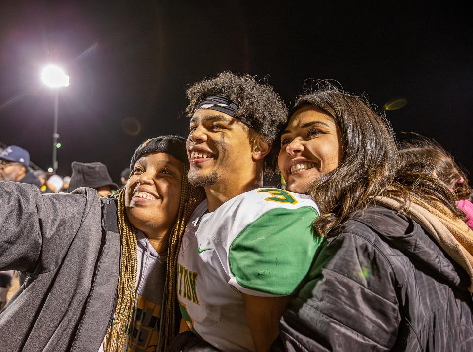 Bryan Station wide receiver J.T. Haskins Jr. celebrated with his aunt and cousin on the field after the Defenders defeated the Ballard Bruins 24-21 in the Class 6A State semifinals on Nov. 24.