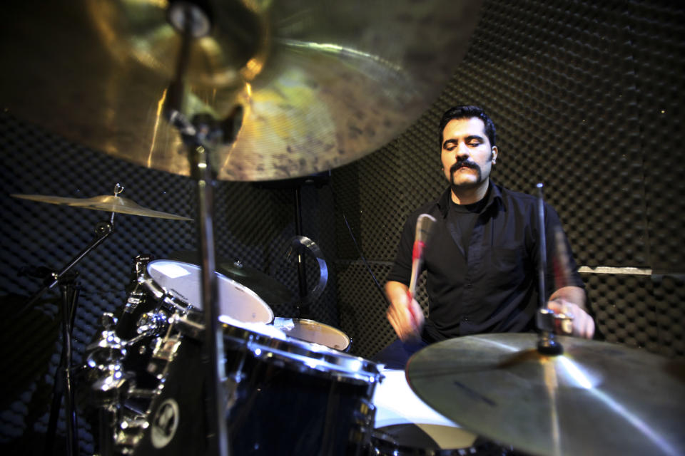 In this picture taken on Friday, Jan. 25, 2013, Iranian musician Ardeshir Jofreh, a member of a band called "Accolade," performs in an unauthorized stage performance in Tehran, Iran. Heavy metal guitarists jamming in basements. Headphone-wearing disc jockeys mixing beats. It’s an underground music scene that is flourishing in Iran, despite government restrictions. (AP Photo/Vahid Salemi)