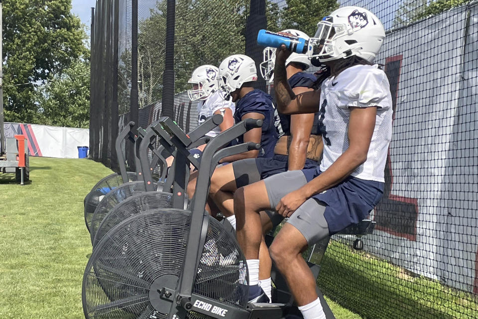 Connecticut players workout on stationary bikes during the opening day of NCAA college football training camp on July 29, 2022, in Storrs, Conn. UConn coach Jim Mora is trying to rebuild the football program as an independent in an era of conference mega-mergers.(AP Photo/Pat Eaton-Robb)