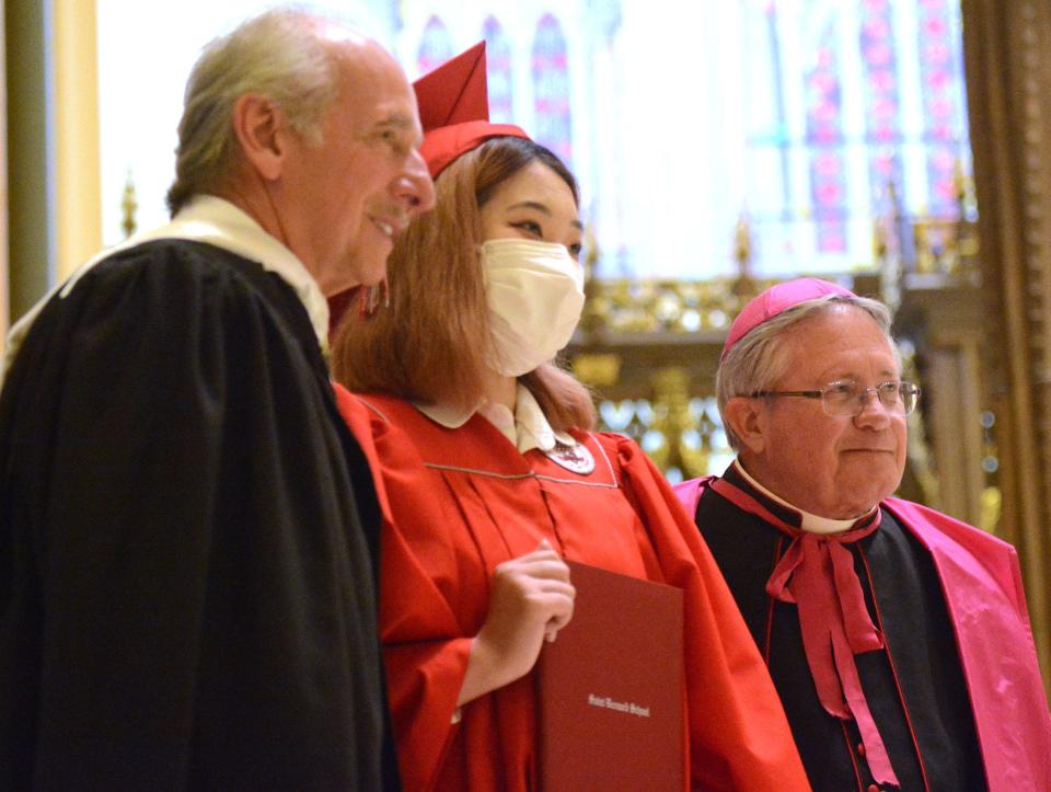 Saint Bernard School graduate Zihan Zhang of Waterford, the last graduate in her class, poses with Donald Macrino, Head of School and The Most Rev. Michael R. Cote, bishop of Norwich during commencement at the Cathedral of Saint Patrick in Norwich.  Fifty-eight young men and women graduated.