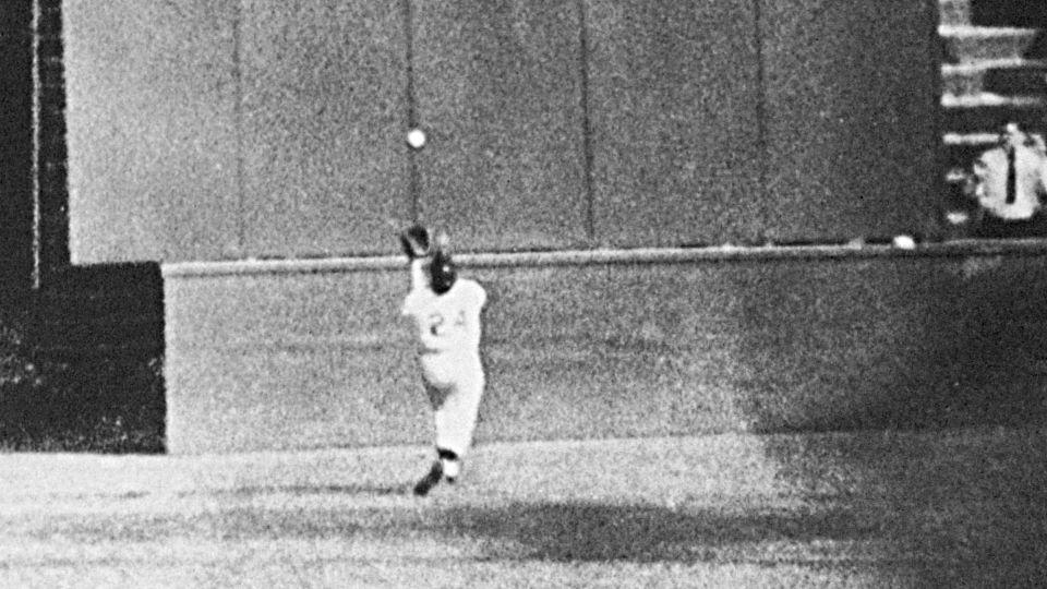 Mays, with his back to the plate, gets under a 450-foot blast off the bat of Cleveland Indians first baseman Vic Wertz to pull the ball down in front of the bleachers wall in the eighth inning of Game 1 of the World Series at the Polo Grounds in New York on September 29, 1954. - AP