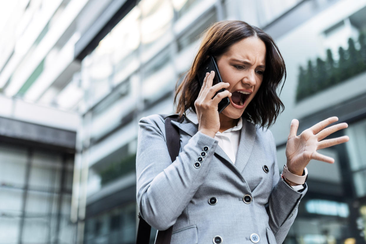 Worried angry businesswoman using phone venting