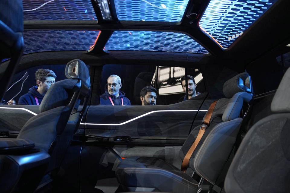 People look inside the Ram 1500 Revolution electric battery powered pickup truck after the Stellantis keynote at the CES tech show Thursday, Jan. 5, 2023, in Las Vegas. (AP Photo/John Locher)