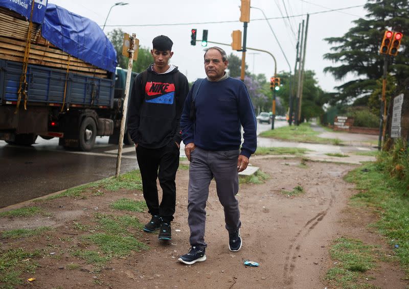 Bricklayer Jose Luis Rodriguez walks with his son to the bus stop on the outskirts of Buenos Aires