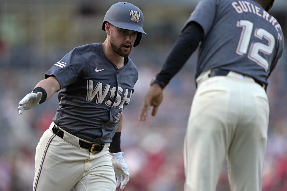 Washington Nationals Lane Thomas, left, is congratulated by third base coach Ricky Gutierrez (12) after hitting a home run in the third inning of a baseball game against the Miami Marlins at Nationals Park in Washington, Friday, June 14, 2024. (AP Photo/Susan Walsh)