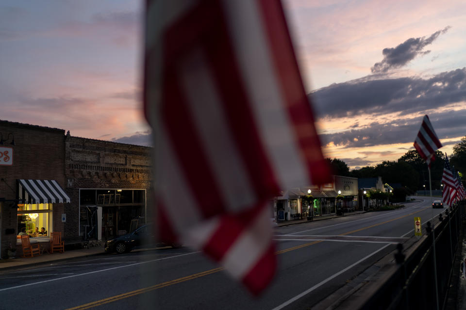 Diners sit in an ice cream shop window as the sun sets in Acworth, Ga., Monday, Aug. 7, 2023. (AP Photo/David Goldman)