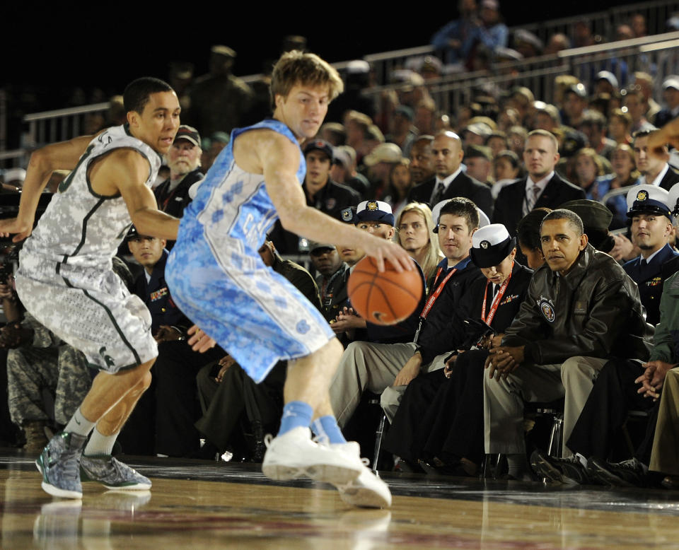 CORONADO, CA - NOVEMBER 11: U.S. President Barack Obama watches Travis Trice #20 of the Michigan State Spartans guard Stilman White #11 of the North Carolina Tar Heels during the Quicken Loans Carrier Classic on board the USS Carl Vinson on November 11, 2011 in Coronado, California. (Photo by Harry How/Getty Images)
