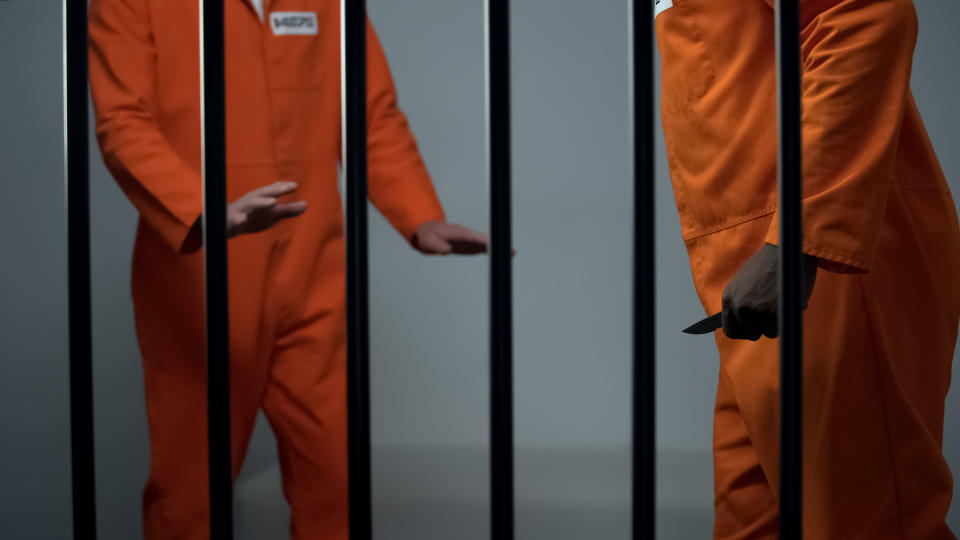 one prisoner passing something to another prisoner