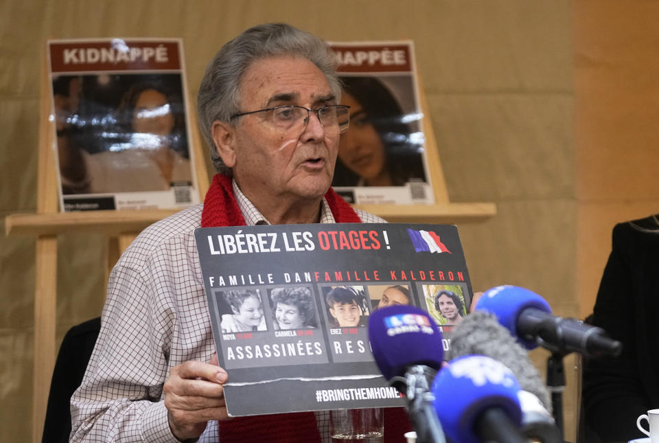 French Israeli Yashay Dan, left, linked to the hostage Ofer Kalderon holds a placard that reads, "free hostages" calls for the release of hostages who were kidnapped on Oct. 7, 2023 during a media conference in Paris, Tuesday, Feb. 6, 2024. (AP Photo/Michel Euler)