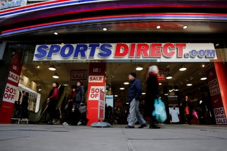 Shoppers walk past Sports Direct store on Oxford Street in London