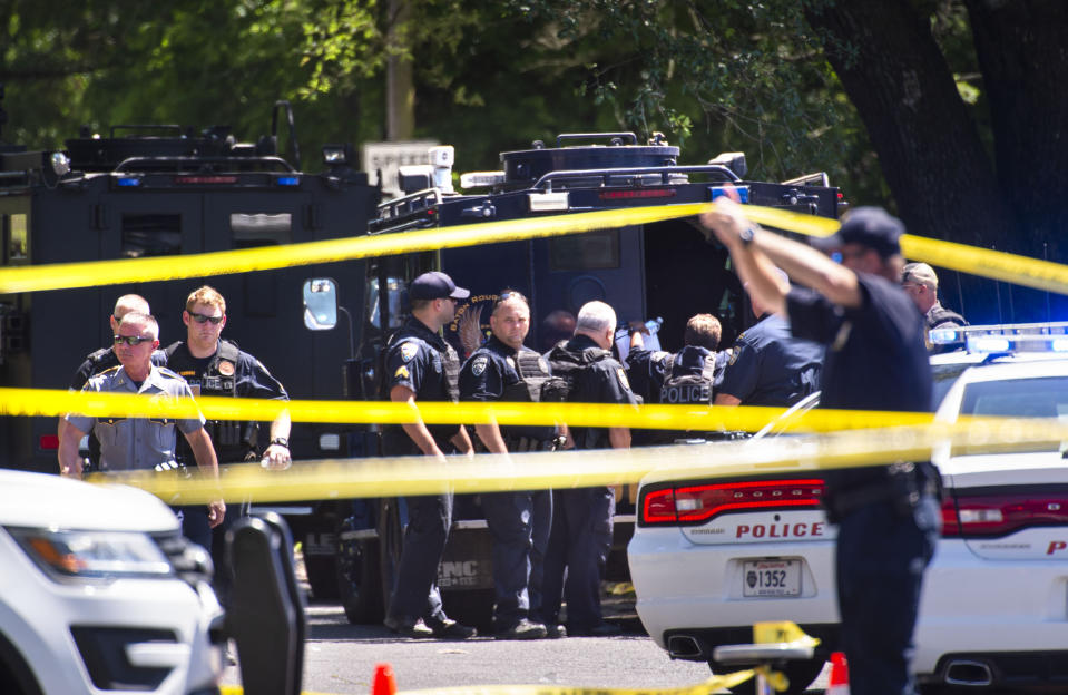 Baton Rouge Police Department officers gather at the site of a shooting in Baton Rouge, La., Sunday, April 26, 2020. The shooting has left one police officer dead and a wounded colleague fighting for life, authorities said, adding a suspect was in custody after an hourslong standoff at a home. Baton Rouge Police Chief Murphy Paul told The Advocate the officers were shot in the northern part of the city, and one of the officers later died. (Travis Spradling/The Advocate via AP)