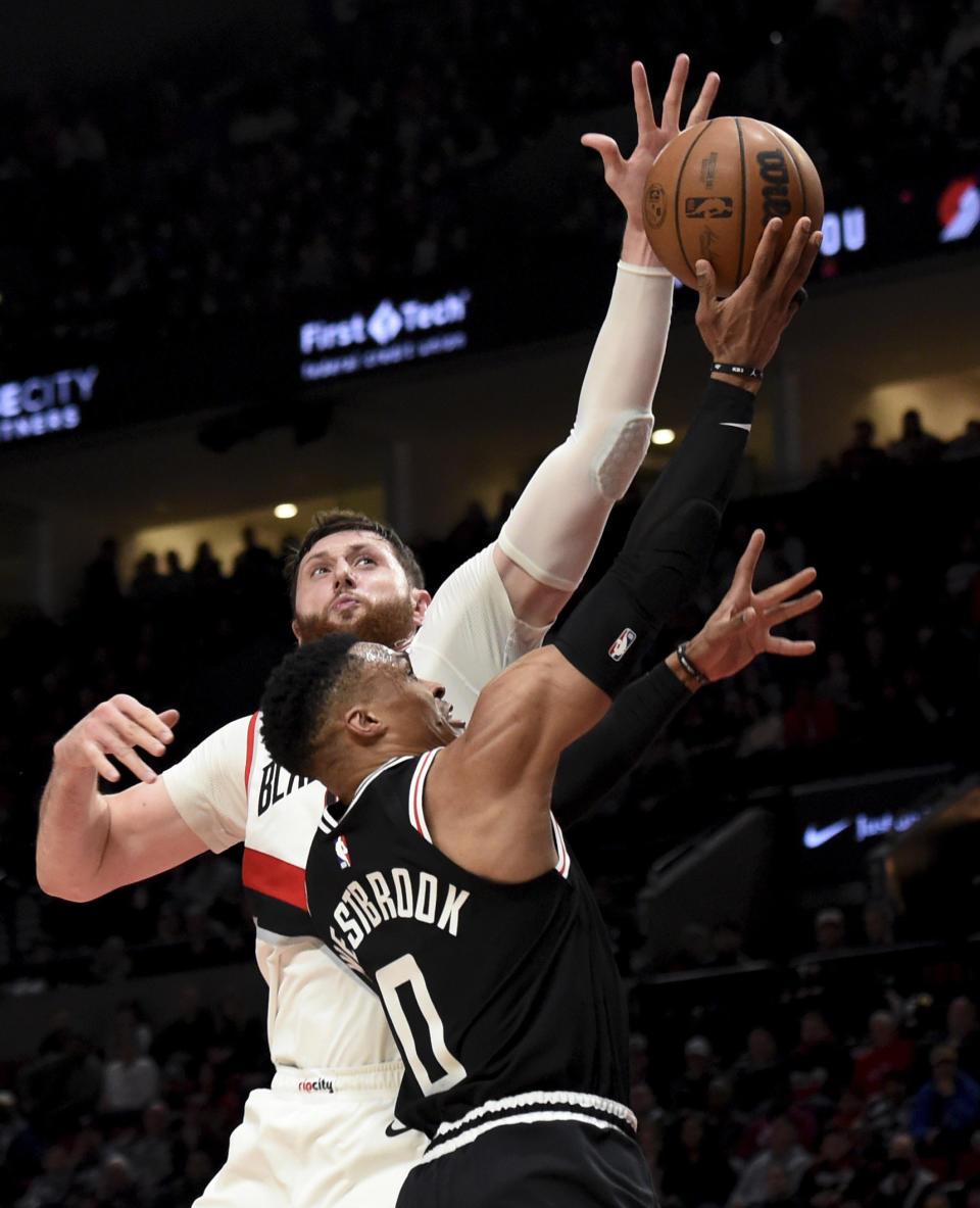 Portland Trail Blazers center Jusuf Nurkic, rear, blocks a shot by Los Angeles Clippers guard Russell Westbrook, front, during the second half of an NBA basketball game in Portland, Ore., Sunday, March 19, 2023. The Clippers won 117-102. (AP Photo/Steve Dykes)