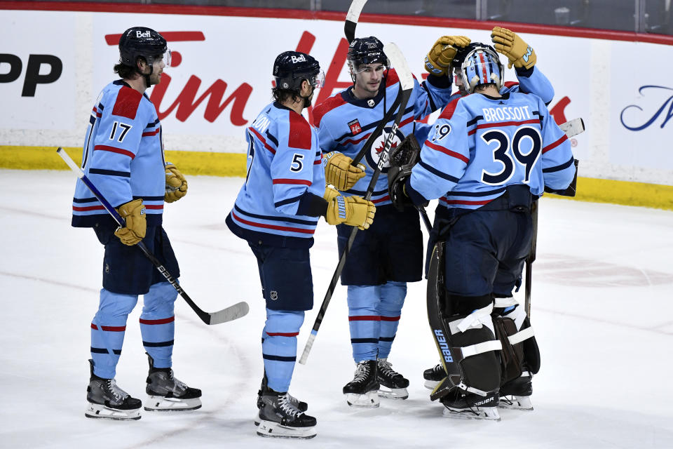 Winnipeg Jets goaltender Laurent Brossoit (39) celebrates the win over the Los Angeles Kings with teammates in an NHL hockey game in Winnipeg, Manitoba, on Monday, April 1, 2024. (Fred Greenslade/The Canadian Press via AP)