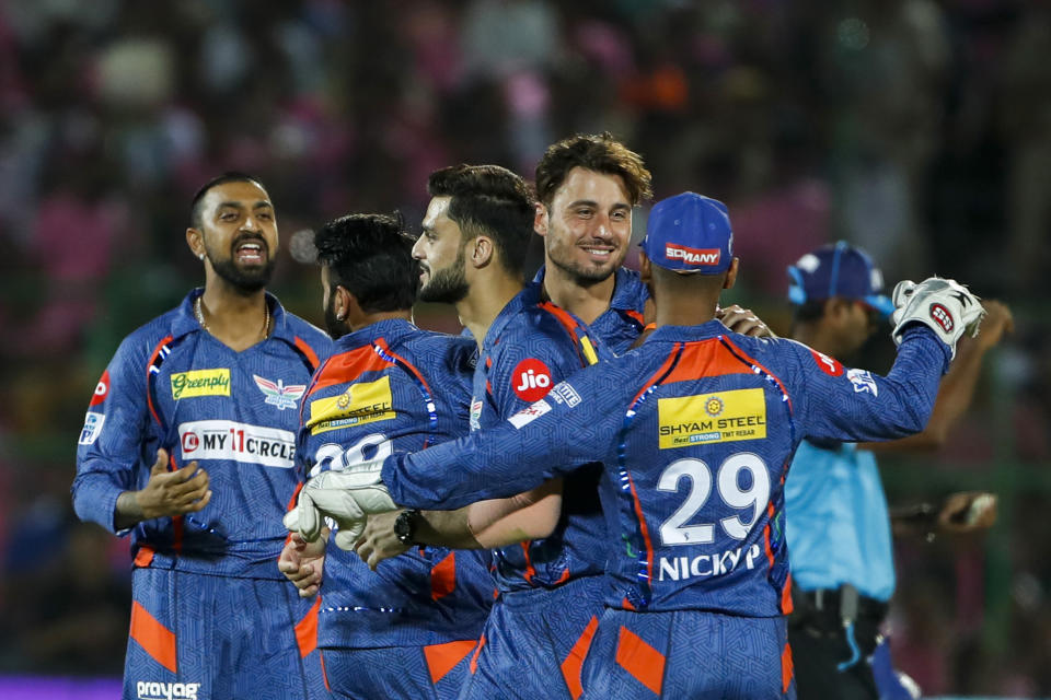 Marcus Stoinis, center, of Lucknow Super Giants celebrates the wicket of Rajasthan Royals' Jos Buttler during the Indian Premier League cricket match between Lucknow Super Giants and Rajasthan Royals in Jaipur, India, Wednesday, April 19, 2023. (AP Photo Surjeet Yadav )