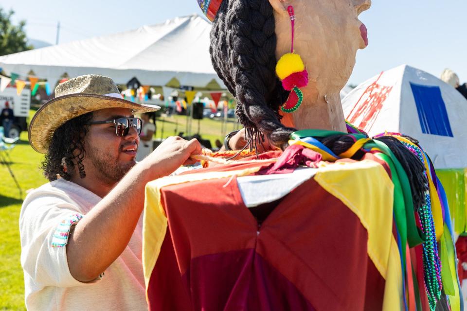 Ramón Ramos assembles large figurines at La Guelaguetza at Heritage Park in Kaysville on Saturday.