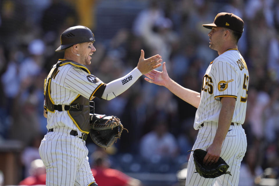 San Diego Padres catcher Brett Sullivan, left, celebrates with relief pitcher Tom Cosgrove after the Padres defeated the Cincinnati Reds 7-1 in a baseball game Wednesday, May 3, 2023, in San Diego. (AP Photo/Gregory Bull)