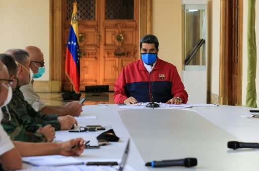 Esta imagen, divulgada por la Presidencia de Venezuela, muestra al presidente, Nicolás Maduro, durante un anuncio televisado sobre la pandemia del nuevo coronavirus, en el palacio de Miraflores, en Caracas, el 22 de marzo de 2020 (Presidencia de Venezuela/AFP | JHONN ZERPA)