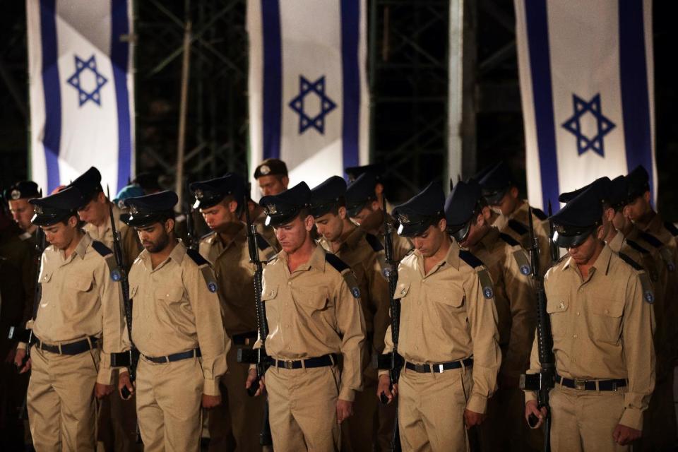 Israeli soldiers observe a minute of silence during a service marking Memorial Day at the Western Wall, the holiest site where Jews can pray, in Jerusalem's Old City, Tuesday, April 24, 2012. Israelis marked Memorial Day starting Tuesday evening in remembrance of the nation's fallen soldiers. (AP Photo/Bernat Armangue)