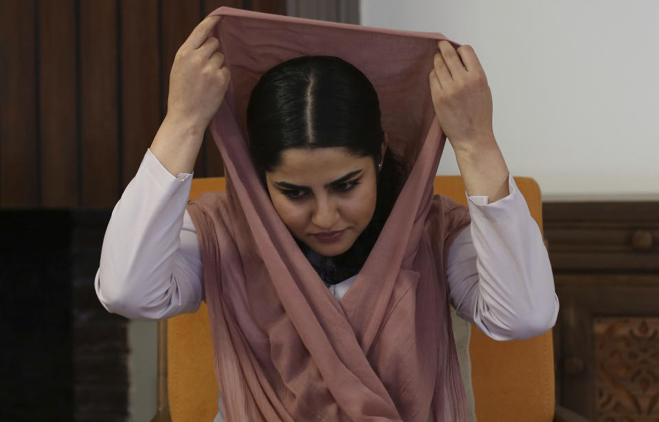 In this Thursday, Aug. 22, 2019 photo, Maryam Sama, a 27-year-old member of Parliament, adjusts her headscarf during an interview with The Associated Press, in Kabul, Afghanistan. Young women in Afghanistan are the most vulnerable population, and perhaps the most defiant, as the United States and the Taliban near a deal on ending America’s longest war. Worried about losing what they've gained over nearly two decades, they are demanding a voice in high-level talks to determine their country’s future. (AP Photo/Rafiq Maqbool)