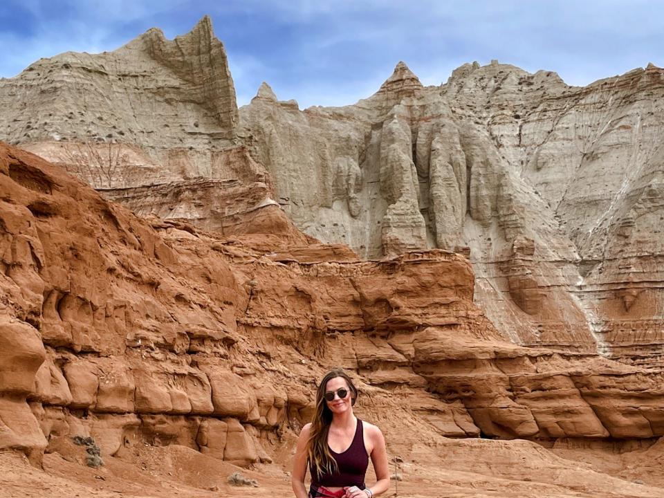 Emily stands in front of massive sand-colored rock formations in Kodachrome Basin State Park.