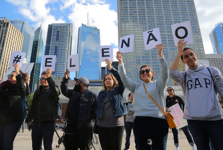 People hold up letters reading "Not Him" in Portuguese during a protest against Brazilian presidential candidate Jair Bolsonaro ahead of the country's elections, outside city hall in Toronto, Ontario, Canada September 29, 2018. REUTERS/Chris Helgren