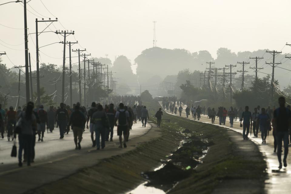 People walk due to roadblocks set up by protesters demonstrating against inflation, especially surging fuel prices, in Pacora, Panama, early Wednesday, July 20, 2022. (AP Photo/Arnulfo Franco)