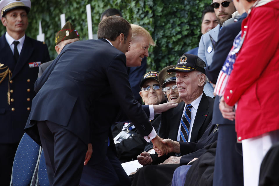 El presidente de Estados Unidos, Donald Trump, y su homólogo francés, Emmanuel Macron, saludan a veteranos a su llegada a una ceremonia para conmemorar el 75 aniversario del Día D en el Cementerio Estadounidense de Normandía, el 6 de junio de 2019, en Colleville-sur-Mer, Normandía, Francia. (AP Foto/Alex Brandon)