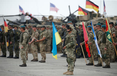 Servicemen from different countries stand at attention during an opening ceremony of the NATO-led military exercises "Noble Partner 2018" at Vaziani military base outside Tbilisi, Georgia, August 1, 2018. REUTERS/David Mdzinarishvili