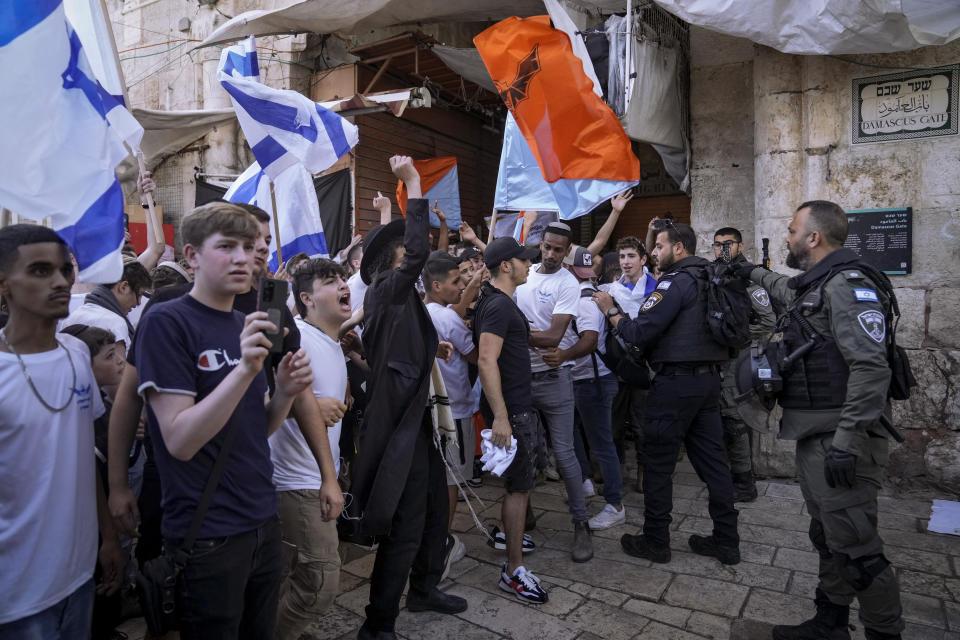 Israelis wave national flags and shout slogans towards Palestinians during a march in Jerusalem's Old City, Thursday, May 18, 2023. The parade was marking Jerusalem Day, an Israeli holiday celebrating the capture of east Jerusalem in the 1967 Mideast war. Palestinians see the march as a provocation. (AP Photo/Mahmoud Illean)