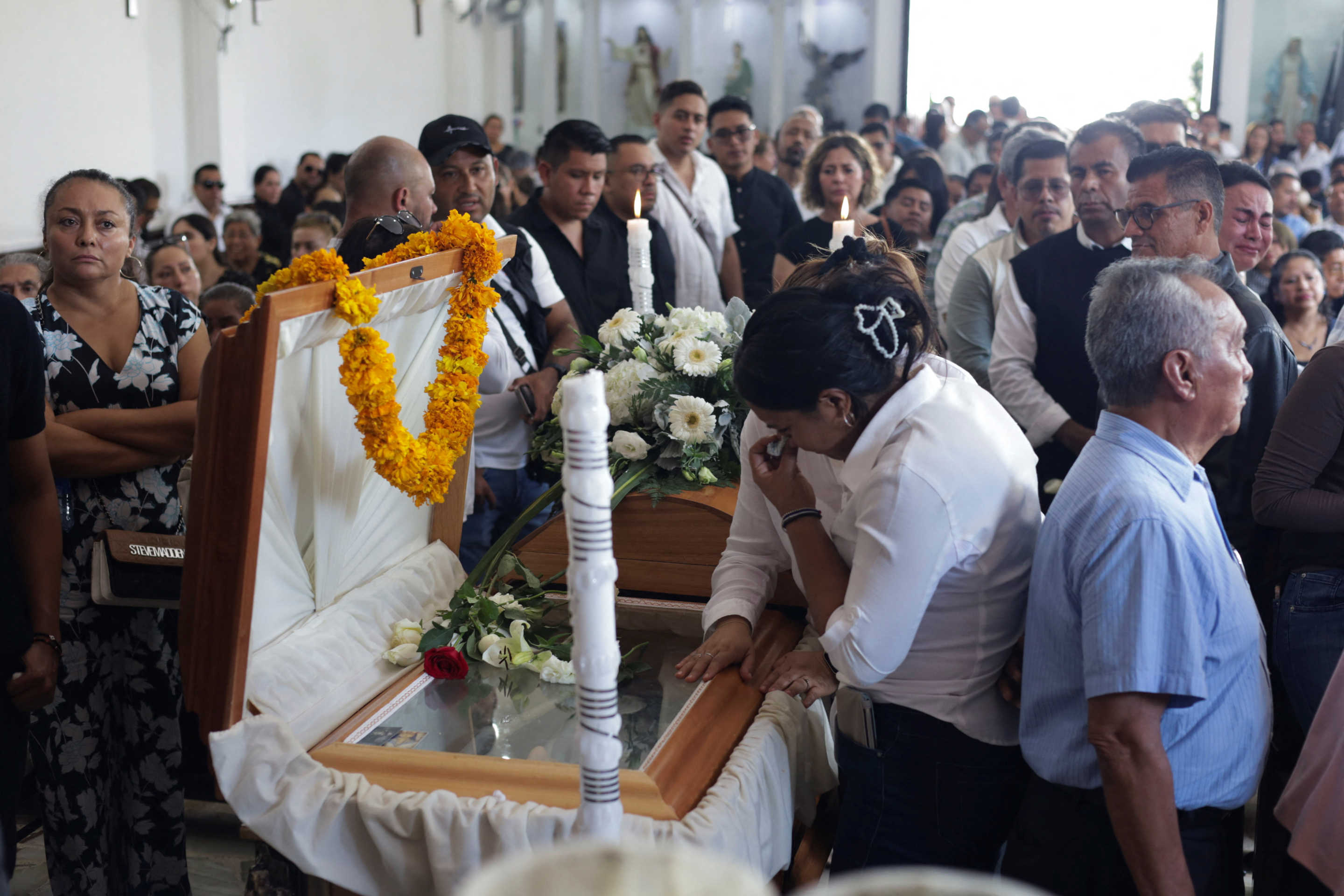 Mourners pay their respects at the casket during the funeral service for Alejandro Arcos, the mayor of Chilpancingo who was killed on Sunday less than a week after taking office, as Mexico's President Claudia Sheinbaum is set to unveil a new security policy, in Chilpancingo, Mexico October 7, 2024. REUTERS/Oscar Ramirez