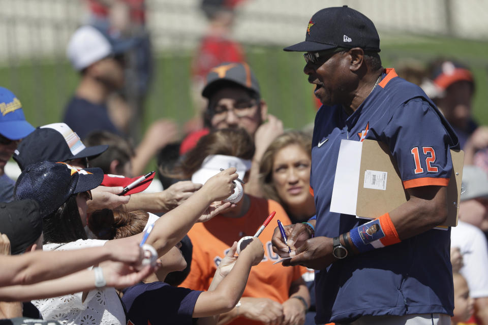 Houston Astros manager Dusty Baker (12) signs autographs for fans before a spring training baseball game against the Washington Nationals Sunday, Feb. 23, 2020, in West Palm Beach, Fla. (AP Photo/John Bazemore)