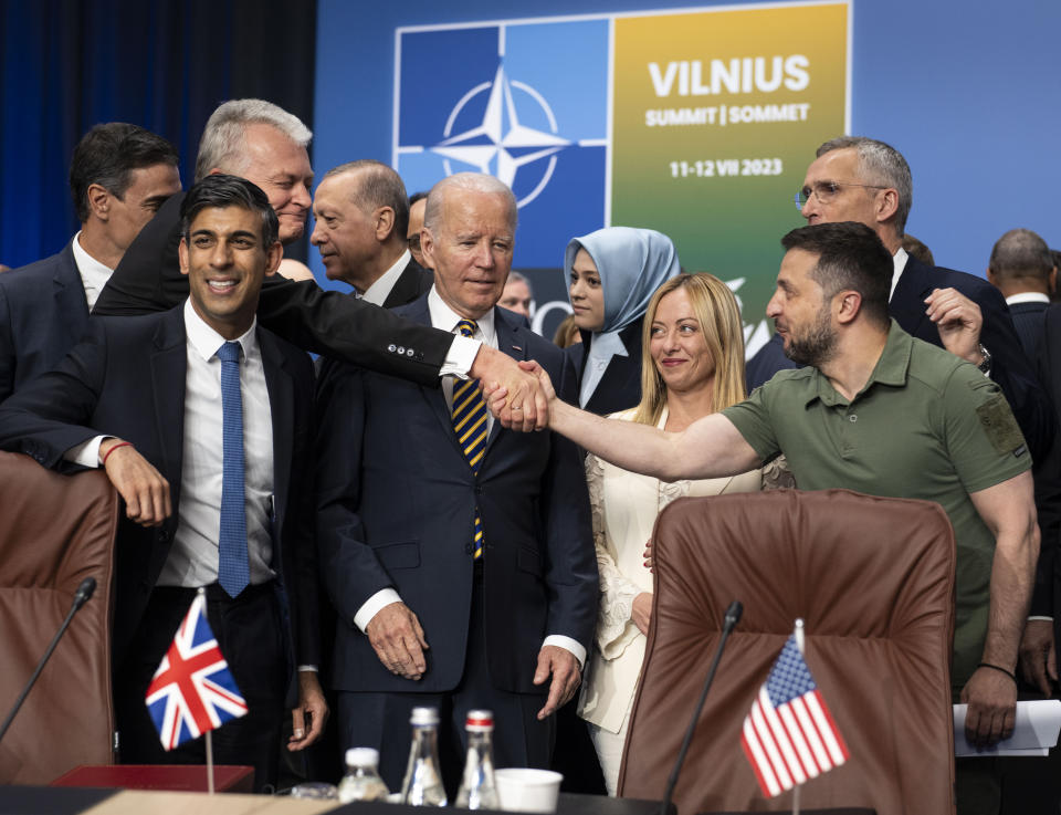 FILE - Ukrainian President Volodymyr Zelenskyy, right, reaches past U.S. President Joe Biden to shake hands with Lithuanian President Gitanas Nauseda as they stand with other NATO members, including British Prime Minister Rishi Sunak, left, during a meeting of the NATO-Ukraine Council in Vilnius, Lithuania, Wednesday, July 12, 2023. As chances rise of a Biden-Donald Trump rematch in the U.S. presidential election race, America’s allies are bracing for a bumpy ride, with concerns rising that the U.S. could grow less dependable regardless of who wins. (Doug Mills/Pool via AP, File)