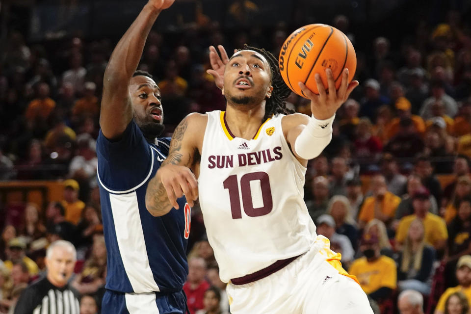 Arizona State's Frankie Collins (10) drives to the basket ahead of Arizona's Courtney Ramey (0) during the first half of an NCAA college basketball game, Saturday, Dec. 31, 2022, in Tempe, Ariz. (AP Photo/Darryl Webb)