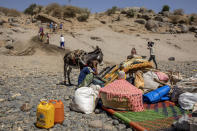 FILE - In this Nov. 21, 2020, file photo, refugees who fled the conflict in Ethiopia's Tigray region arrive with their furniture and donkey on the banks of the Tekeze River on the Sudan-Ethiopia border, in Hamdayet, eastern Sudan. Huge unknowns persist in the deadly conflict, but details of the involvement of neighboring Eritrea, one of the world's most secretive countries, are emerging through witness accounts by survivors and others. (AP Photo/Nariman El-Mofty, File)