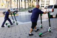 John Heinkel and Dan Borelli of Scoot Scoop impound four scooters that were left on private property in downtown San Diego