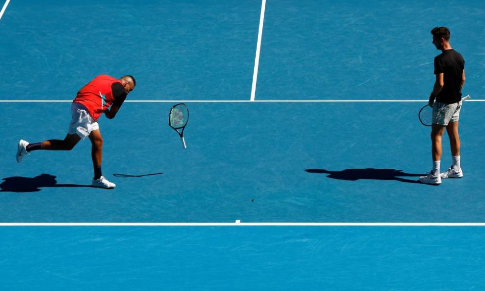 Nick Kyrgios breaks his racket while Thanasi Kokkinakis looks on.