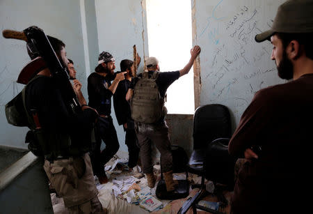 Rebel fighters from Jaysh al-Sunna, operating under a coalition of rebel groups called Jaish al-Fatah, or the army of conquest, gather inside a building at a lookout point in Aziziyah village, southern Aleppo countryside, Syria May 17, 2016.. REUTERS/Khalil Ashawi