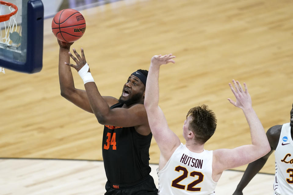 Oregon State forward Rodrigue Andela (34) drives to the basket past Loyola Chicago center Jacob Hutson (22) during the first half of a Sweet 16 game in the NCAA men's college basketball tournament at Bankers Life Fieldhouse, Saturday, March 27, 2021, in Indianapolis. (AP Photo/Darron Cummings)