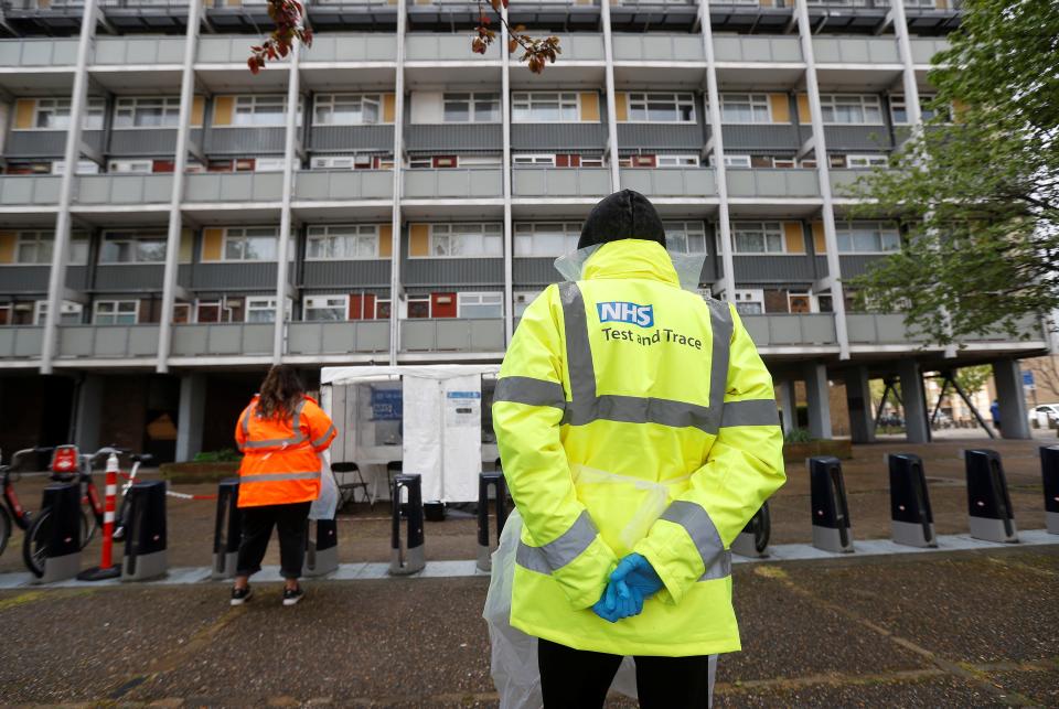 NHS workers stand near a coronavirus mobile testing unit in Tower Hamlets (REUTERS)