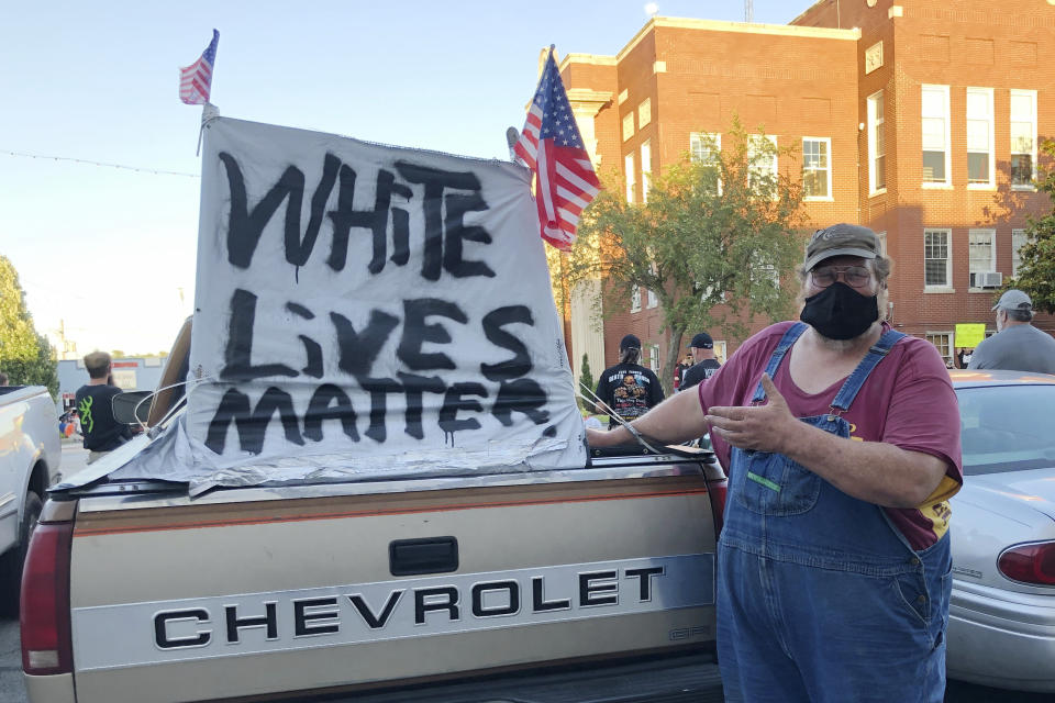 This June 10, 2020 photo shows Michael Johnson, part of a group that believed antifa was coming to Leitchfield, Ky., when a local resident organized a Black Lives Matter rally. He said the sign he affixed to his truck was meant to say that all people's lives should matter equally. Johnson said he was troubled by George Floyd's death under the knee of a police officer, but worried the protests across the country would devolve into violence and vandalism. (AP Photo/Claire Galofaro)