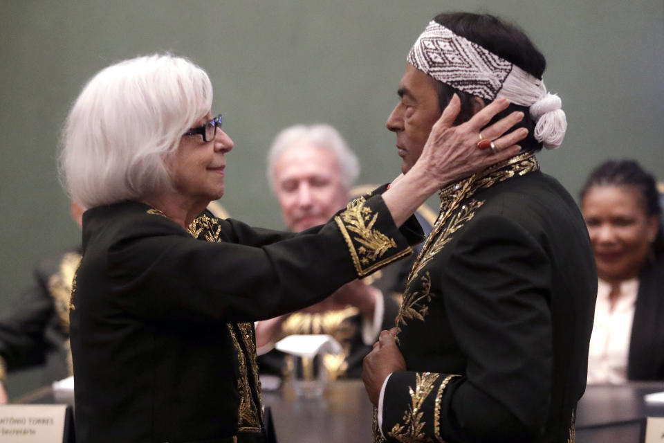 Writer Fernanda Montenegro holds Indigenous writer and environmental activist Ailton Krenak during his admission ceremony to the Brazilian Academy of Letters, in Rio de Janeiro, Brazil Friday, April 5, 2024. Krenak is the first Indigenous person to be elected to the academy. (AP Photo/Bruna Prado)