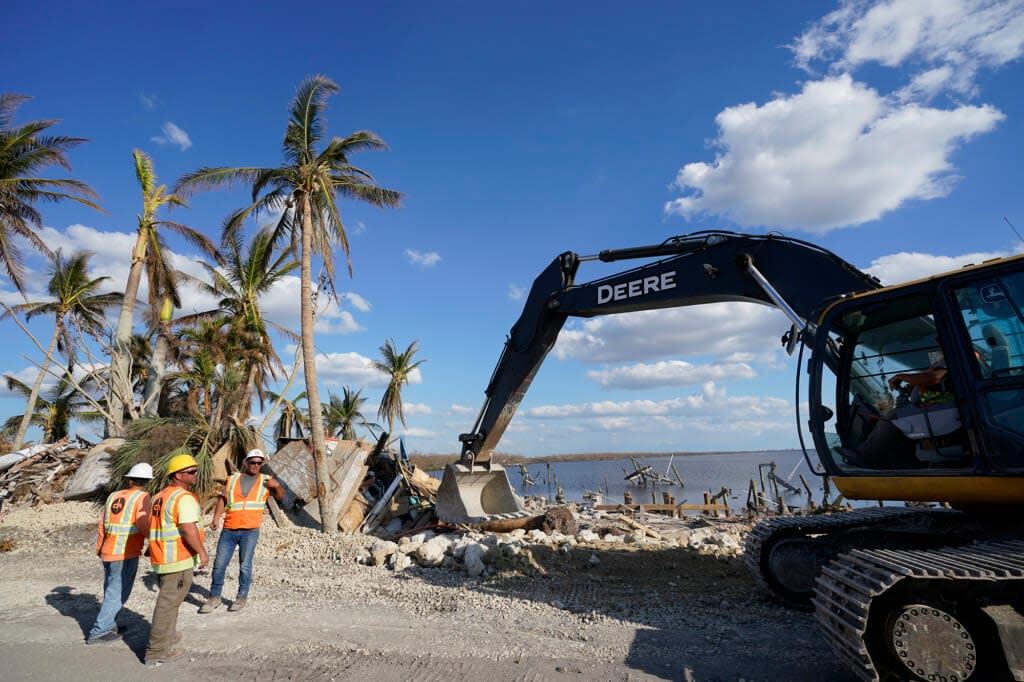 Workers clear debris caused by damage in Hurricane Ian, Thursday, Oct. 6, 2022, in Matlacha in Lee County, Fla. (AP Photo/Wilfredo Lee)