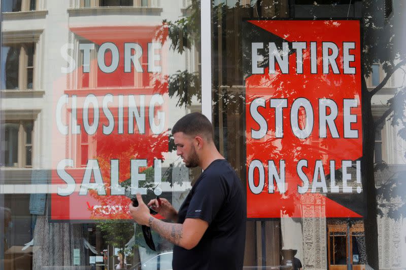 FILE PHOTO: FILE PHOTO: A man walks past signs in the windows of Lord & Taylor, advertising a store closing sale, in Boston