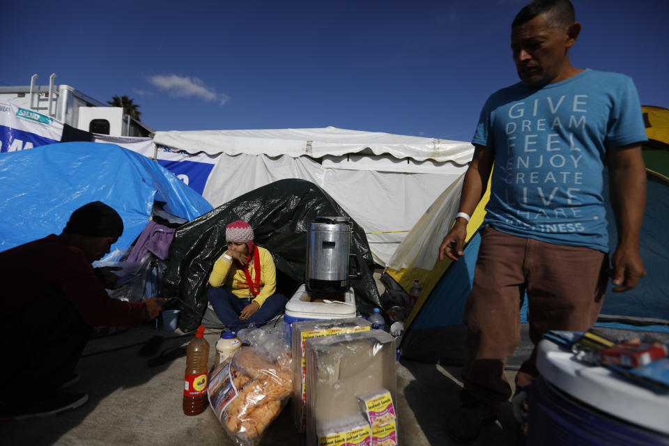 In this Dec. 2, 2018 photo, Honduran migrant Jose Daniel Castro Herrera, 44, stands next to his tent where he sells, coffee, noodles and gum inside the former concert venue Barretal, now serving as a shelter for more than 2,000 migrants in Tijuana, Mexico. Castro, who has already been deported three times from the U.S. for living and working in the country without authorization, said he had joined the caravan to come to Tijuana and find work there to help support his sick mother. (AP Photo/Rebecca Blackwell)