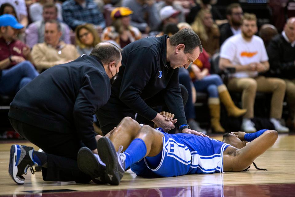 Duke coach Mike Krzyzewski holds the hand of injured guard Trevor Keels during the second half half of the tema's NCAA college basketball game against Florida State in Tallahassee, Fla., Tuesday Jan. 18, 2022. Florida State won 79-78 in overtime.